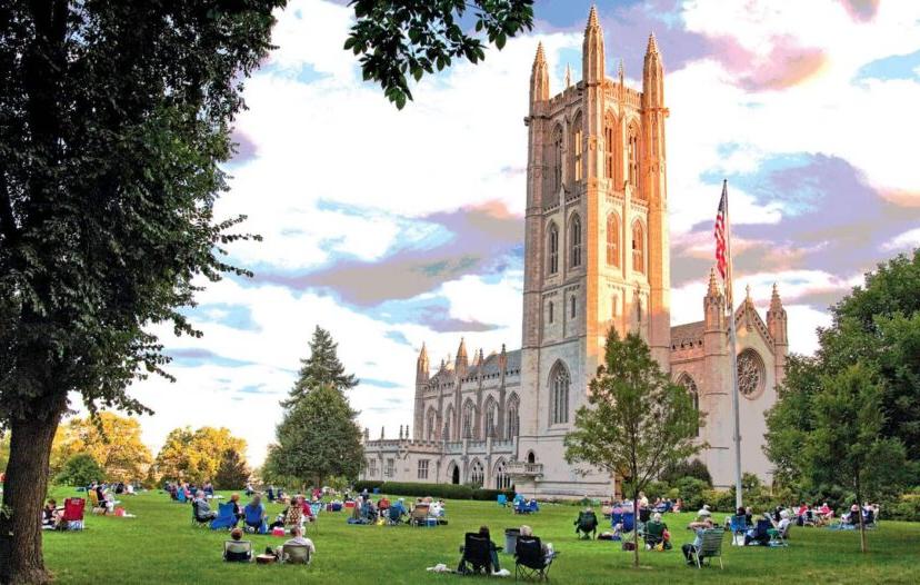 The Trinity College Chapel with students sitting on the grass